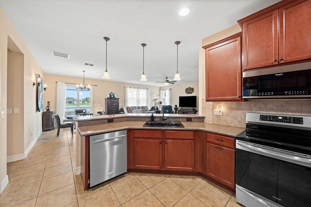 kitchen with decorative backsplash, decorative light fixtures, ceiling fan with notable chandelier, and stainless steel appliances