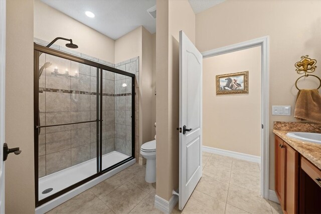 bathroom featuring tile patterned flooring, an enclosed shower, vanity, and toilet