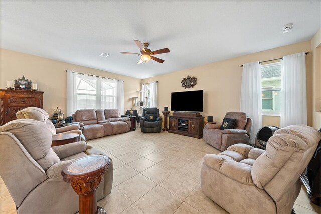 tiled living room with a healthy amount of sunlight and ceiling fan