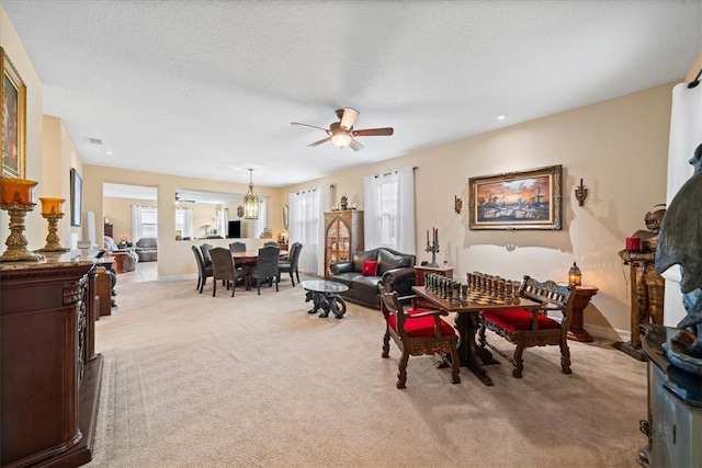 carpeted dining area featuring a textured ceiling and ceiling fan