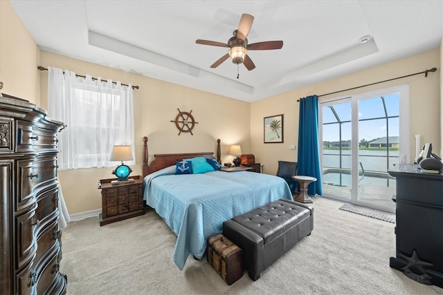 bedroom with a tray ceiling, multiple windows, and ceiling fan