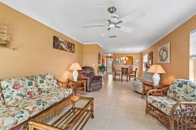 tiled living room with crown molding and ceiling fan with notable chandelier