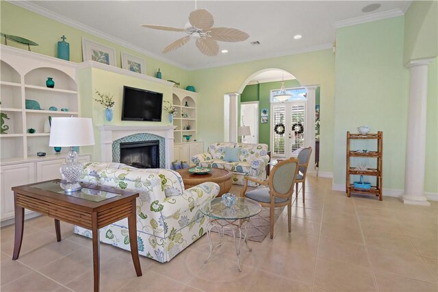 living area with light tile patterned floors, ornamental molding, a fireplace, and decorative columns