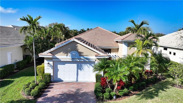 view of front of property featuring a front lawn, decorative driveway, an attached garage, and stucco siding