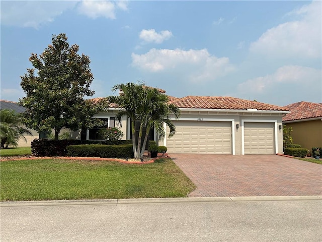 5582 49th Ave, Vero Beach, FL 32967 - view of front of home with decorative driveway, a garage, a tile roof, a front yard, and stucco siding