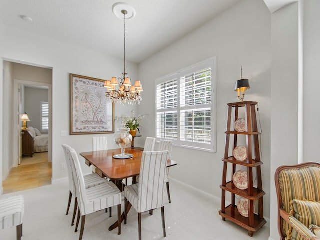 carpeted dining space featuring a chandelier