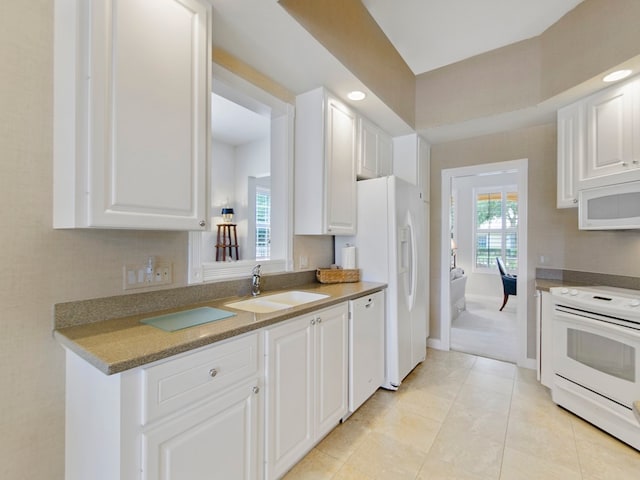 kitchen with sink, white cabinets, and white appliances