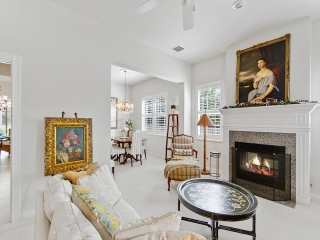 living room with ceiling fan with notable chandelier, light carpet, and a textured ceiling