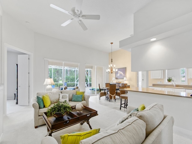 carpeted living room with a healthy amount of sunlight, ceiling fan with notable chandelier, and a high ceiling