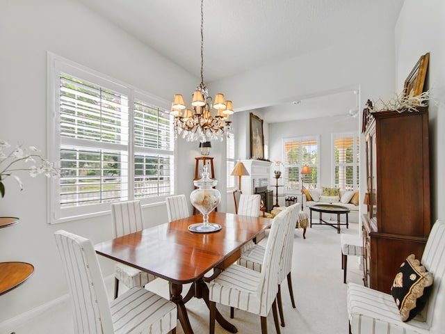 carpeted dining room with an inviting chandelier and vaulted ceiling