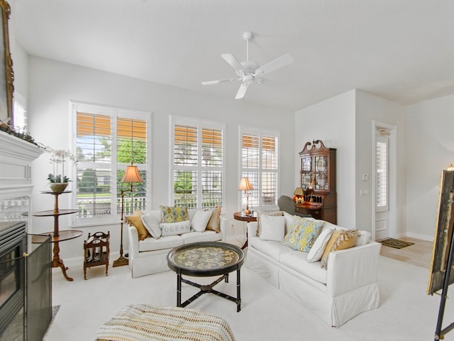 living room featuring a tile fireplace, plenty of natural light, and ceiling fan