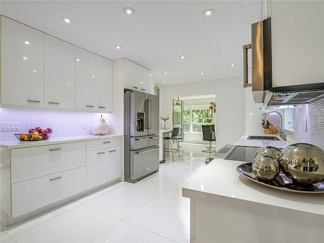 kitchen featuring high end refrigerator, white cabinets, modern cabinets, and a sink