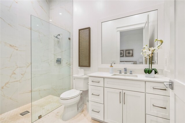 bathroom featuring toilet, vanity, and tiled shower