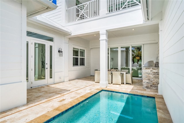 view of swimming pool featuring a patio and french doors