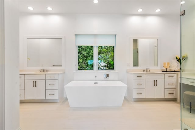 bathroom with a tub and vanity