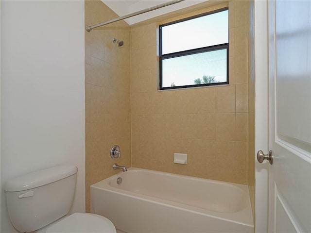 bathroom featuring toilet and tiled shower / bath combo