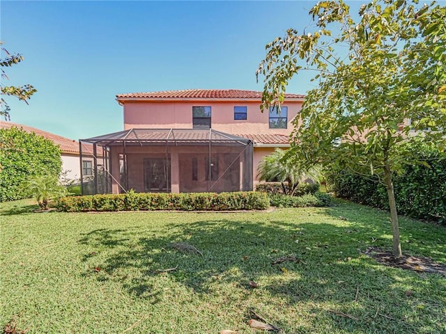 rear view of property with a lanai and a lawn