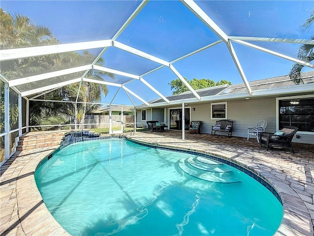 outdoor pool with a lanai, a patio, and fence