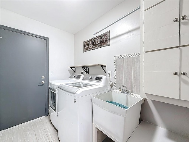 washroom featuring a sink, washing machine and dryer, and laundry area