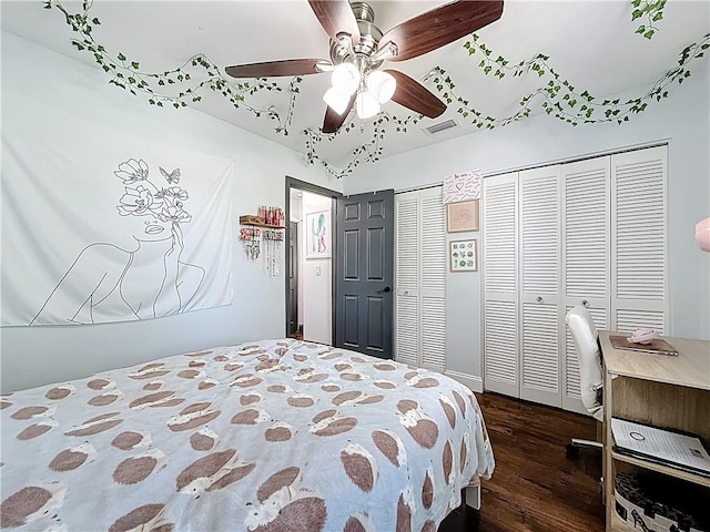 bedroom featuring visible vents, wood finished floors, multiple closets, and ceiling fan