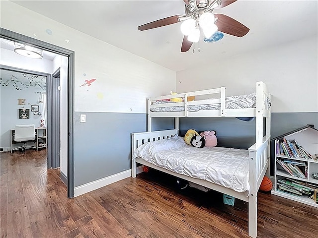 bedroom featuring baseboards, wood finished floors, and a ceiling fan