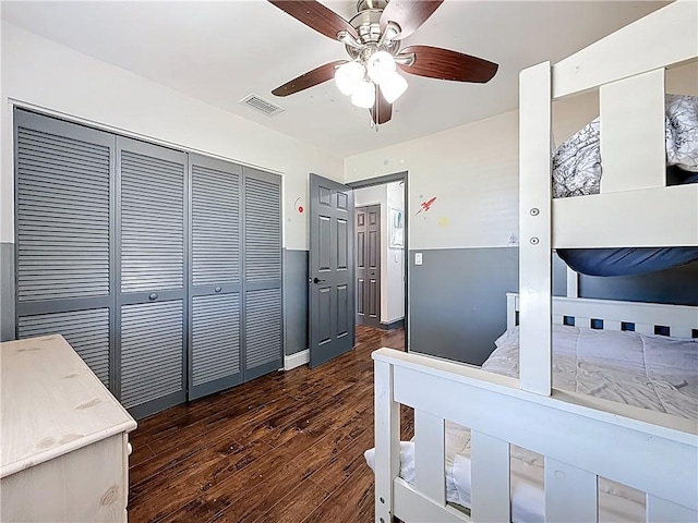 bedroom with visible vents, baseboards, wood finished floors, a closet, and a ceiling fan