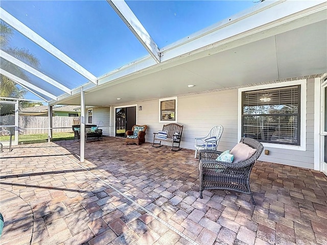 view of patio with a lanai and fence