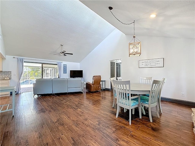 dining area featuring baseboards, ceiling fan with notable chandelier, a textured ceiling, high vaulted ceiling, and dark wood-style flooring