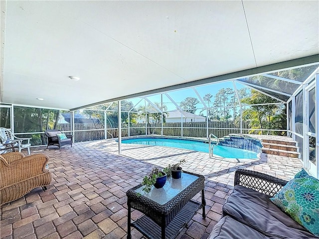 view of pool with glass enclosure, a patio, and a fenced backyard