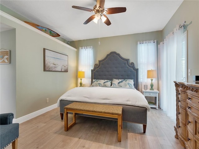 bedroom with ceiling fan, light wood-type flooring, and multiple windows