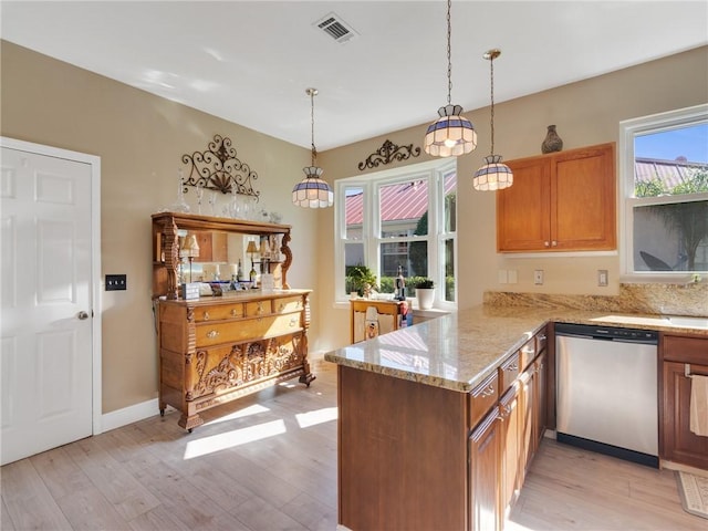 kitchen featuring kitchen peninsula, light wood-type flooring, stainless steel dishwasher, light stone counters, and pendant lighting