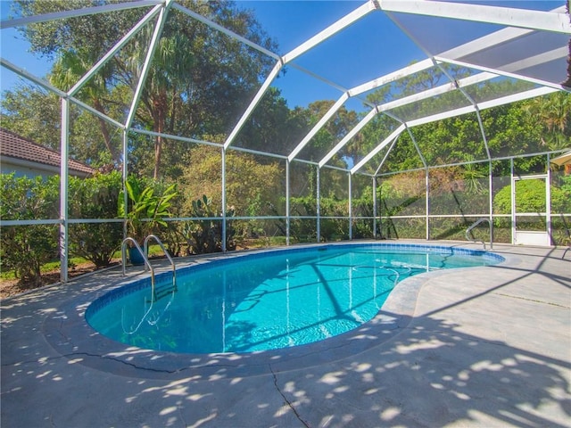 view of swimming pool with glass enclosure and a patio