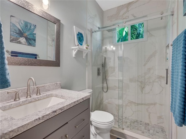 bathroom with toilet, an enclosed shower, and vanity