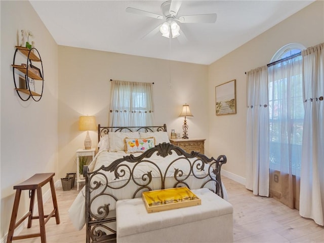 bedroom with ceiling fan, light hardwood / wood-style floors, and multiple windows