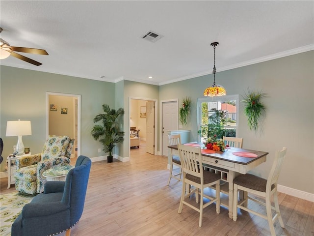 dining space with ceiling fan, light wood-type flooring, and crown molding