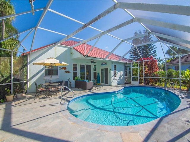 view of pool featuring a lanai, ceiling fan, and a patio area