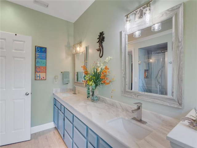 bathroom with vanity, an enclosed shower, and hardwood / wood-style flooring