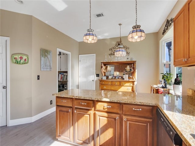 kitchen with stainless steel dishwasher, light hardwood / wood-style floors, light stone countertops, and hanging light fixtures