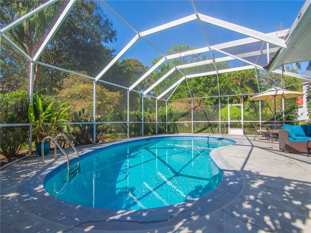 view of swimming pool featuring glass enclosure and a patio area