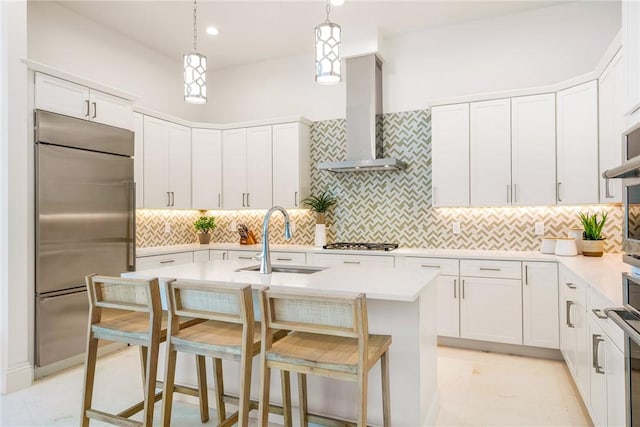 30 Strand Dr, Vero Beach, FL 32963 - kitchen with stainless steel appliances, wall chimney range hood, a kitchen island with sink, light countertops, and recessed lighting