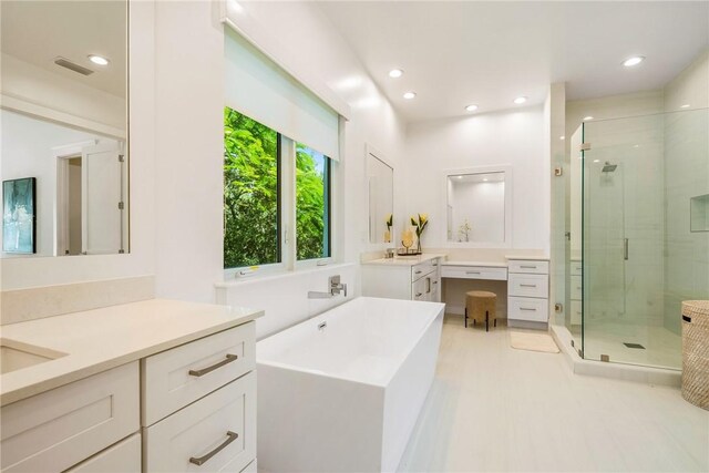 30 Strand Dr, Vero Beach, FL 32963 - bathroom with a stall shower, a freestanding tub, two vanities, and recessed lighting