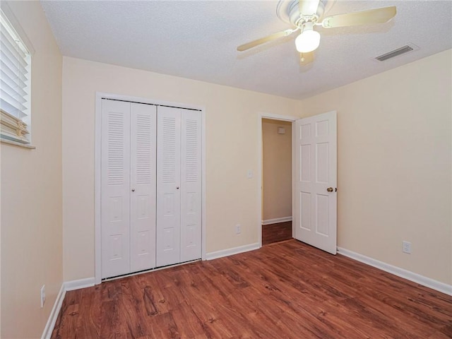 unfurnished bedroom featuring visible vents, baseboards, and wood finished floors