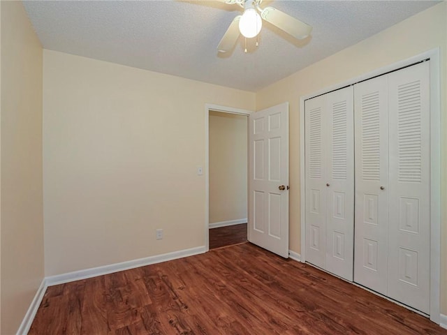 unfurnished bedroom featuring ceiling fan, baseboards, wood finished floors, a closet, and a textured ceiling