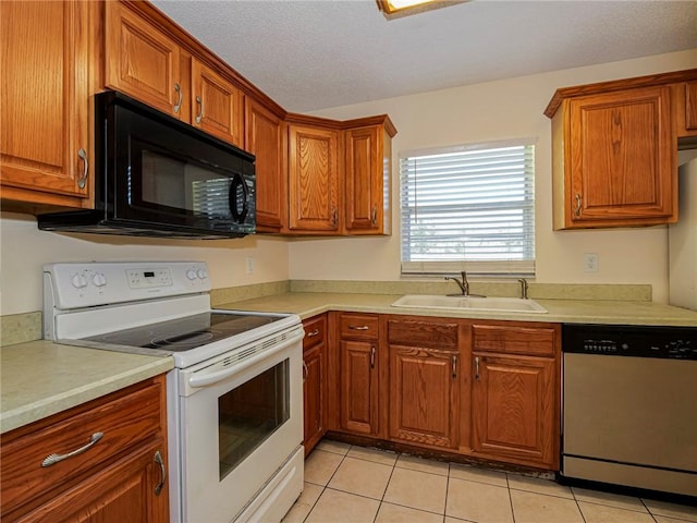 kitchen featuring a sink, stainless steel dishwasher, white electric range oven, black microwave, and light countertops