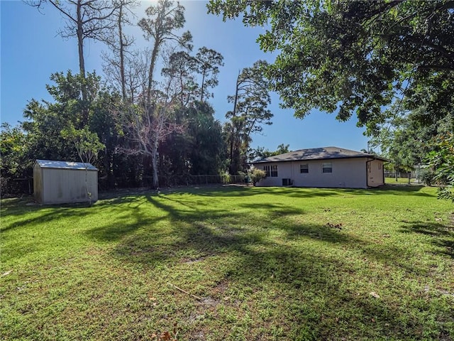 view of yard with an outdoor structure, fence, and a shed