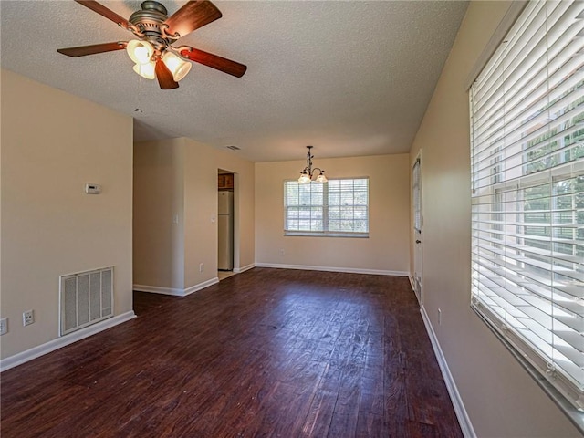 spare room featuring wood finished floors, baseboards, visible vents, a textured ceiling, and ceiling fan with notable chandelier