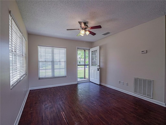 unfurnished room with visible vents, baseboards, a ceiling fan, and hardwood / wood-style flooring