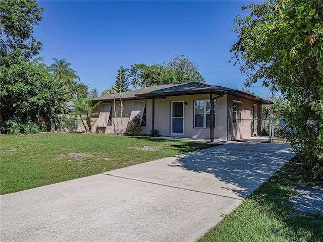 view of front of home with stucco siding, concrete driveway, a front yard, and fence