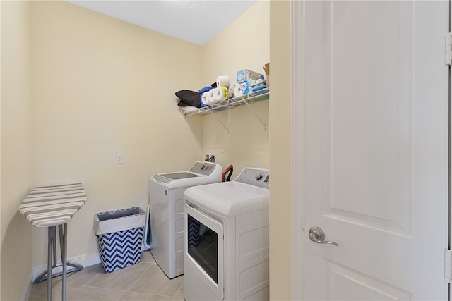 laundry area with washing machine and dryer and light tile patterned floors