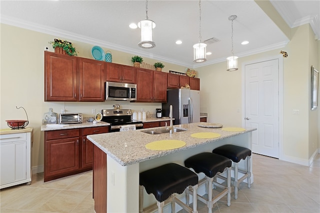 kitchen with a kitchen island with sink, a breakfast bar, decorative light fixtures, and appliances with stainless steel finishes